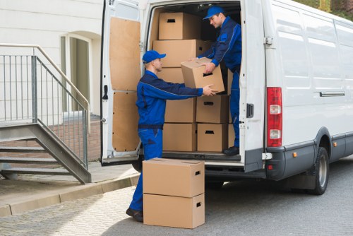 Man with van removal team loading furniture for a local move in Movers